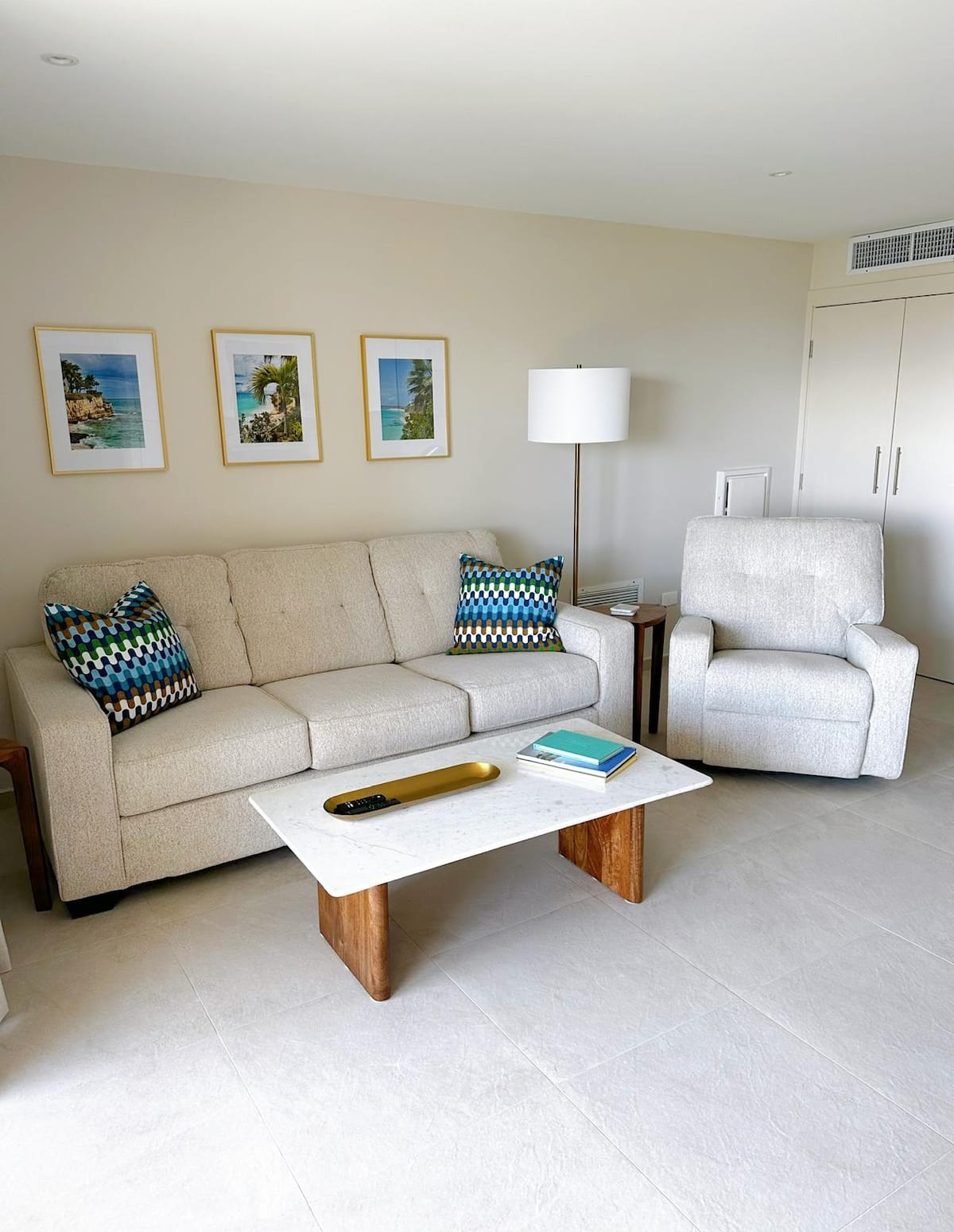 One Love Maho living room with white sofa and teal accent chairs